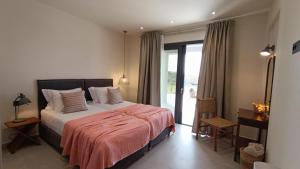 a bedroom with a bed and a sliding glass door at Villa GEIA in Klísmata +47 photos