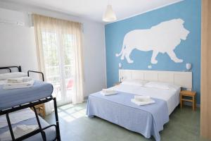 a bedroom with two beds and a cat on the wall at Hotel Aloha dipendenza Villa Silvie Rose in Cesenatico