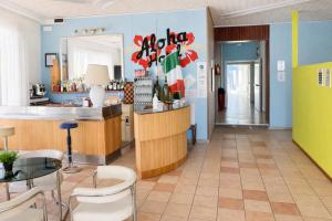 a restaurant with a counter and chairs in a room at Hotel Aloha dipendenza Villa Silvie Rose in Cesenatico