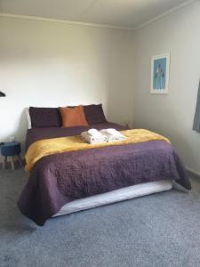 a bedroom with a bed with two towels on it at Kiwiana Gem in Reefton