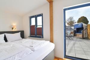 a bedroom with a white bed and a large window at Blankenese in Ahlbeck