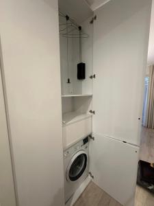 a white laundry room with a washing machine in it at Fly & Pool Apartment in Palanga +17 photos
