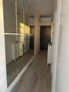 a room with glass walls and a hallway with a room with at Fly & Pool Apartment in Palanga