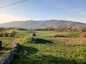 a field with a fence and mountains in the background at Mountain hideaway in Finny