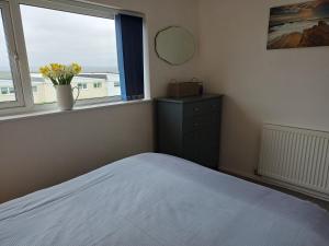 a bedroom with a bed and a window and a dresser at Chalet 18 Widemouth Bay Holiday Village in Bude +21 photos