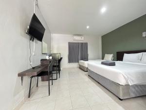 a bedroom with a bed and a desk and a television at Hatyai Bangkok Resort หาดใหญ่ บางกอก รีสอร์ท in Hat Yai