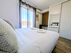 a bedroom with a large white bed with towels on it at La Régalide 2A in Roquebrune-Cap-Martin