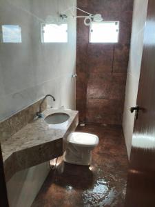 a bathroom with a toilet and a sink at Lar Doce Lar Realizando Sono suíte1 in Arcos