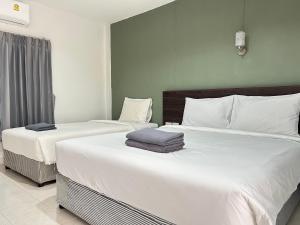 two beds in a hotel room with white sheets at Hatyai Bangkok Resort หาดใหญ่ บางกอก รีสอร์ท in Hat Yai +26 photos
