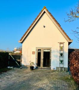a large white building with a large door at B&B Mirre in Kapelle +16 photos