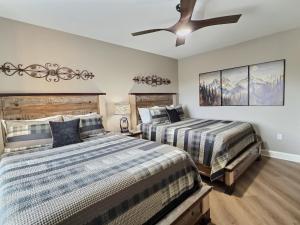 a bedroom with two beds and a ceiling fan at Serenity at the Summit in Gatlinburg