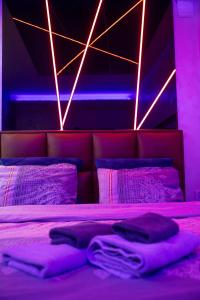 a purple bedroom with a bed with purple lights at Foča Apartman STORY LUX in Foča +12 photos