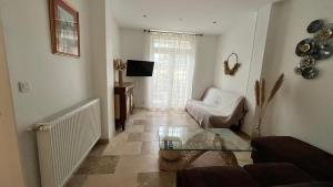 a living room with a couch and a glass table at Maison de ville Libourne 3 chambres in Libourne