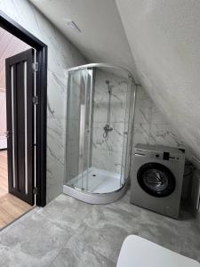 a bathroom with a shower and a washing machine at Odessky Dvorik in Chişinău