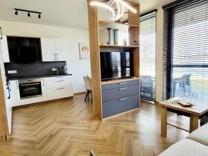 a kitchen and living room with a couch and a table at Ostoja Orli Dziób B2 in Kal