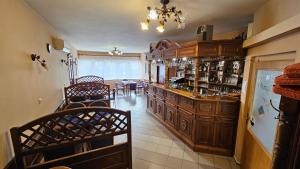a bar with wooden cabinets and chairs in a room at Penzión Magnólia in Trenčín