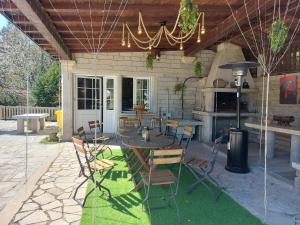 a patio with a table and chairs and a stove at Casa Quercus Galicia, a 17 minutos de Santiago! in A Estrada