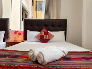 a bedroom with a bed with towels on it at Machu Picchu Sacred Valley in Machu Picchu