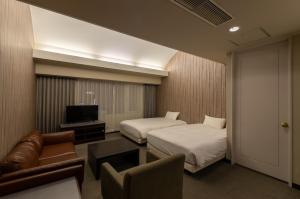 a hotel room with two beds and a couch at Court Hotel Asahikawa in Asahikawa +53 photos