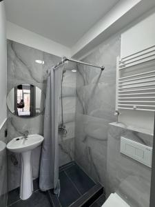 a white bathroom with a sink and a shower at Columna Home in Chişinău