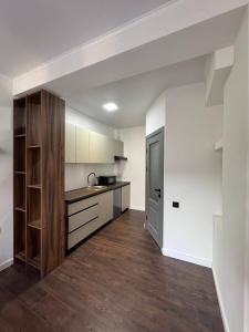 an empty kitchen with white walls and wooden floors at Columna Home in Chişinău