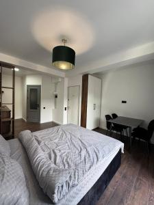 a bedroom with a large bed and a table at Columna Home in Chişinău