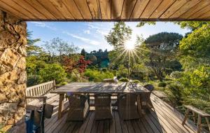 a wooden deck with a table and chairs at Orion Treehouses in Saint Paul de Vence