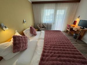 a hotel room with a large bed and a desk at Hotel Hohe Wart in Herbrechtingen
