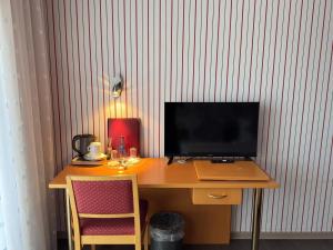 a desk with a computer and a monitor on it at Hotel Hohe Wart in Herbrechtingen