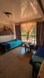 a bedroom with a bed and a couch and a table at El Nido Cerro Azul in Cerro Azul