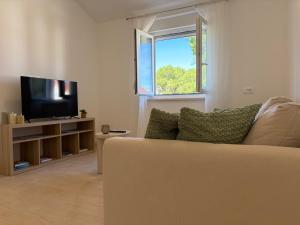 a living room with a couch and a flat screen tv at Apartments Verde in Lumbarda
