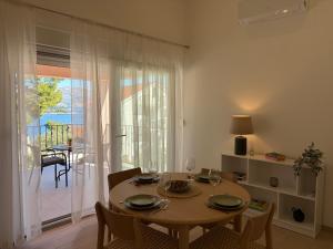 a dining room with a table and a view of a balcony at Apartments Verde in Lumbarda