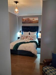 a bedroom with a large bed with a blue headboard at Casa de Marcos in Swakopmund