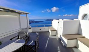a balcony with chairs and a view of the ocean at Yposkafo Suites - Villa - Santorini in Fira