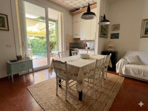 a dining room with a table with chairs and a kitchen at La casa di Giò in Varazze