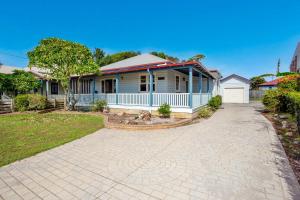 a house with a driveway in front of it at The Lakes Cottage in Tea Gardens