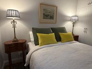 ein Schlafzimmer mit einem Bett mit gelben Kissen und zwei Lampen in der Unterkunft Towerview in Benalla