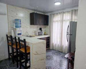 a kitchen with a counter and a refrigerator at Micheck beach house in Tortuguero