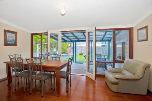 a dining room with a table and chairs at The Lakes Cottage in Tea Gardens