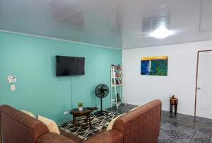 a living room with two couches and a flat screen tv at Micheck beach house in Tortuguero