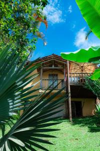a house with a palm tree in front of it at Chales Sol Paraty in Paraty