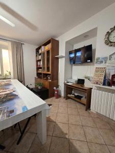 a living room with a table and a tv on the wall at La Piazza B&B in Vercurago