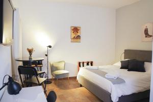 a bedroom with a bed and a table and a chair at Residenza Toscanini in Ravenna