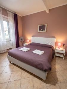 a bedroom with a large bed with two towels on it at La Piazza B&B in Vercurago