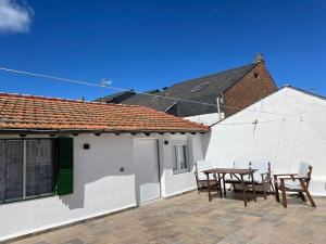 a patio with chairs and a table and a building at Las raíces de los abuelos in Guadalix de la Sierra