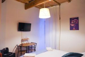a bedroom with a bed and a table and a television at Residenza Toscanini in Ravenna