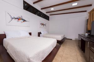 Кровать или кровати в номере Café de Playa Beach Front Hotel