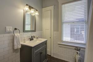 a bathroom with a sink and a mirror and a window at Classic Woodwork and Details in 1912 Colonial in Memphis +18 photos