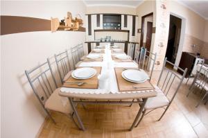 a long dining room table with white plates and chairs at Noclegi ZŁOTA RYBKA in Toruń