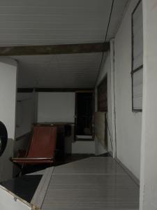 an empty room with a chair and a white wall at Paradise in Natal